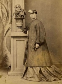 Mary Anne Downes, da Nova Zelândia, tenta disfarçar sua gravidez com um casaco largo na década de 1870.